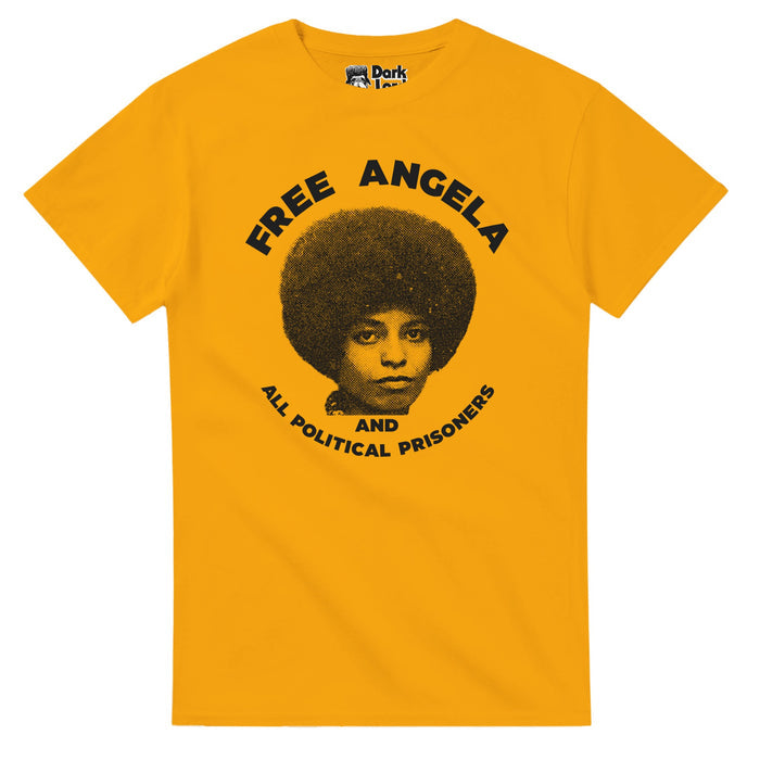 A mustard yellow colored retro, souvenir t-shirt that says FREE ANGELA AND ALL POLITICAL PRISONERS, referencing the 2012 documentary of the same name that centered Angela Davis' story, activism, involvement in the Communist Party and Black Panthers, a botched kidnapping attempt, her place on the FBI's most wanted list, and her trial, & stars Angela Davis & Eisa Davis. The shirt includes an image of Angela Davis in black and white looking towards the camera, her hair in an afro, similar to the mo