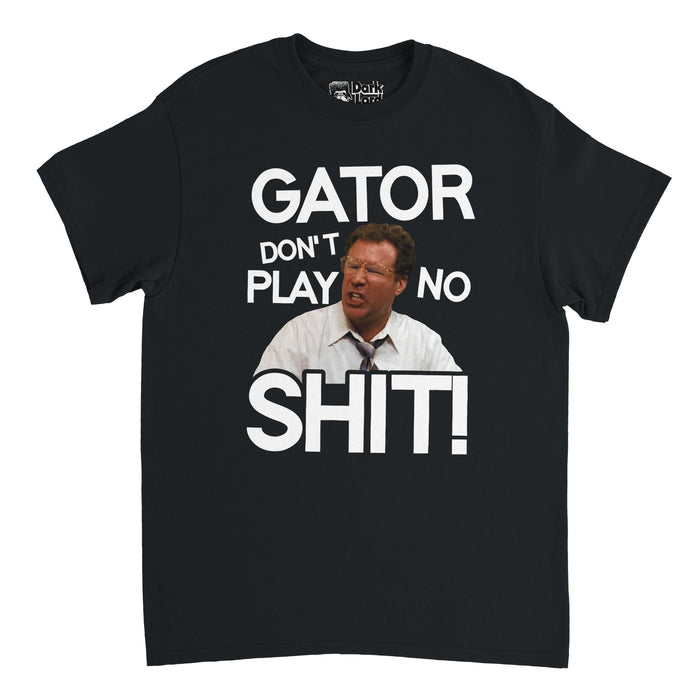 A retro, souvenir black t-shirt that says in big white letters "Gator Don't Play No Shit" in reference to the iconic Will Ferrell as Detective Allen Gamble quote from the classic 2010 comedy film "The Other Guys", with an image of the actor in a white shirt and red tie, face red from arguing, in the center of the shirt.