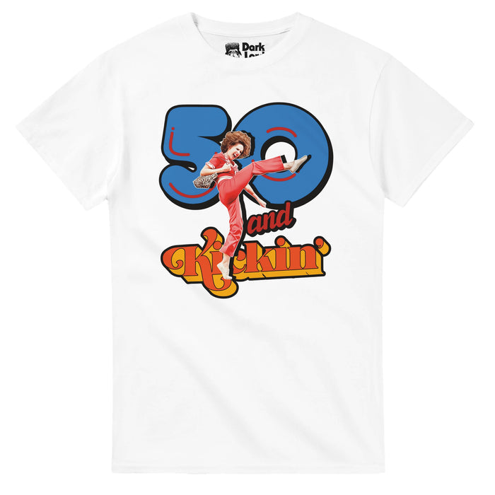 A retro, white colored 80s style t-shirt that says "50 and Kickin'" in bright blue, red, and orange, bubble letters of different fonts, an image of the iconic character Salley O'Malley kicking her leg up, wearing her bright red jumpsuit, holding a cheetah print bag, her hair in a bouffant hairstyle. References the iconic Saturday Night Live skit starring recurring character Sally O'Malley (played by Molly Shannon) and her famous catchphrase: "I like to kick, and stretch, and KICK! I'm 50!"