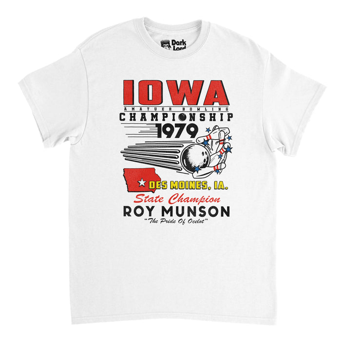 A retro, white colored 80s style t-shirt that says 'Iowa Amatuer Bowling Championship 1979, Des Moines, IA. State Champion Roy Munson, "The Pride of Ocelot"'. References the 1996 comedy sports film "Kingpin" starring Woody Harrelson as bowling champion Roy Munson, Bill Murray as Erne McCracken, and Vanessa Angel as Claudia. Shirt includes an image of a bowling ball knocking over multiple red striped bowling pins, adorned with blue stars, and a red map of Iowa state with a star on its capital, De