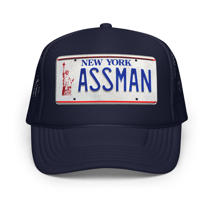 A retro, vintage navy colored trucker hat with the image of a car license plate that says "New York ASSMAN" in blue letters with an image of the statue of liberty in red. In reference to the character Cosmo Kramer, played by actor Michael Richards, who gets his renewed license plate in the comedy sitcom television series "Seinfeld".