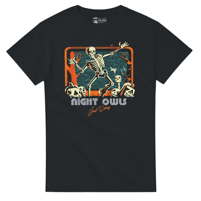 A black colored 80s style short sleeved souvenir t-shirt that says "Night Owls with Jack Delroy" under an image of multiple skeletons and carved pumpkin jack-o-lanterns in orange creepy woods dancing against a blue/black background. References the 2023 supernatural film "Late Night With The Devil" directed by Colin and Cameron Cairnes starring David Dastmalchian as Jack Delroy, rival of Johnny Carson, a late night host of his show 'Night Owls' and the ensuring horror that takes place on Hallowee
