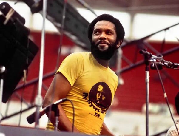 Roy Ayers, singer, musician, and vibraphonist, stands on stage, performing at the Kool Jazz Festival in Cincinnati in 1976 in a yellow t-shirt with a picture of himself on it right after the release of his iconic, world famous album "Everybody Loves the Sunshine."