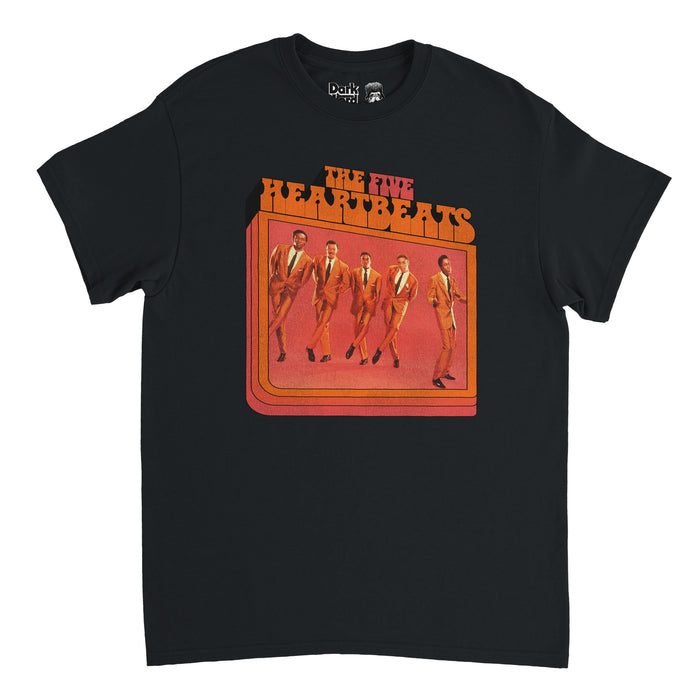 A vintage, black colored 70s style t-shirt that says "The Five Heartbeats" in capitalized red and orange text above an image of five Black men dressed in dapper orange suits performing Motown music against a backdrop of a reddish color. References The Five Heartbeats movie from 1991 based on multiple artists such as The Dells and The Temptations, starring Robert Townsend, Leon Robinson, Michael Wright, Harry Lennix, and Tico Wells as Duck, JT, Eddie, Dresser, and Choirboy.