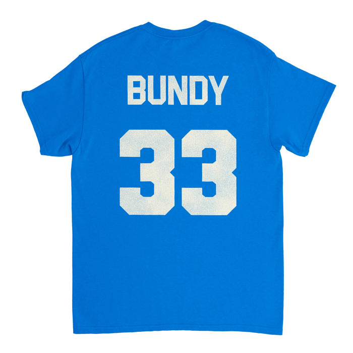 The back of a bright blue, retro short sleeved t-shirt and costume that says "Bundy" and has the number "33" on the back in block white letters. References the character Al Bundy (Alphonse Bundy) played by Ed O'Neill from the 1987 sitcom television series "Married... with Children" in which character Al Bundy was a star fullback football player from Polk High School.