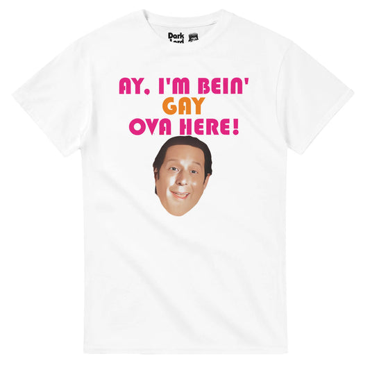 A vintage, 70s style t-shirt in the color white that says 'Ay, I'm Bein' Gay Ova Here!' in orange and pink bright letters above an image of the iconic character Sean Rinaldi, played by the actor Anthony Atamanuik. References the comedy fantasy television series "What We Do in the Shadows" in which this exact shirt was held up by Sean.