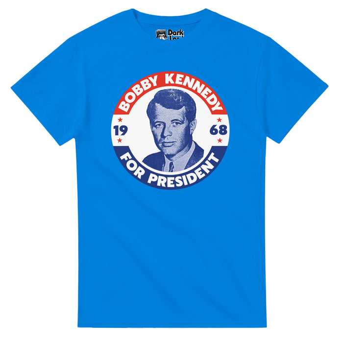 A retro, blue colored t-shirt that says "Bobby Kennedy For President", the year "1968" with a blue toned image of Bobby Kennedy in the center of a circle with red, white, and blue colors and stars. References Robert F. Kennedy, a lawyer, politician, and former United States Attorney General, known as RFK, the brother of former president John F. Kennedy (JFK), also assassinated during his run for the Democratic presidential nomination in June 1968.