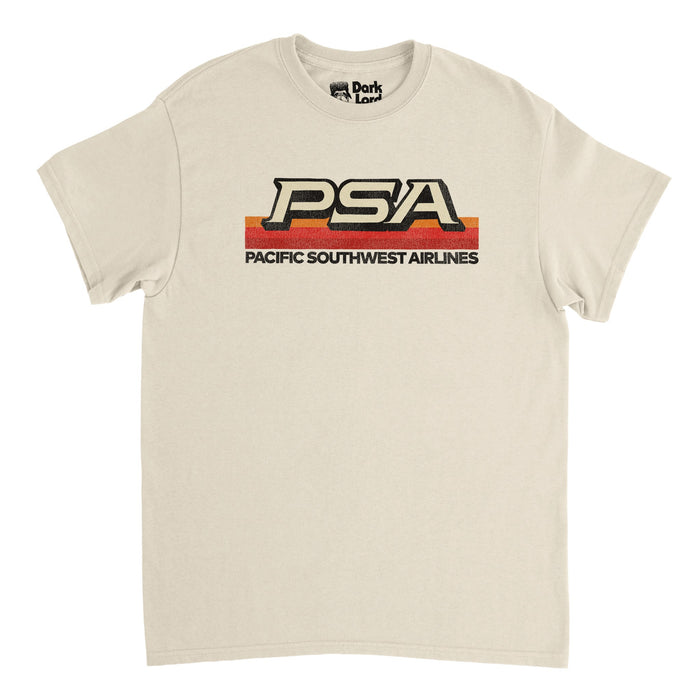 A vintage, 70s style sand colored t-shirt that says PSA - standing for Pacific Southwest Airlines, which ran from 1949 to 1988- with its iconic orange, red, and maroon striped logo graphic.
