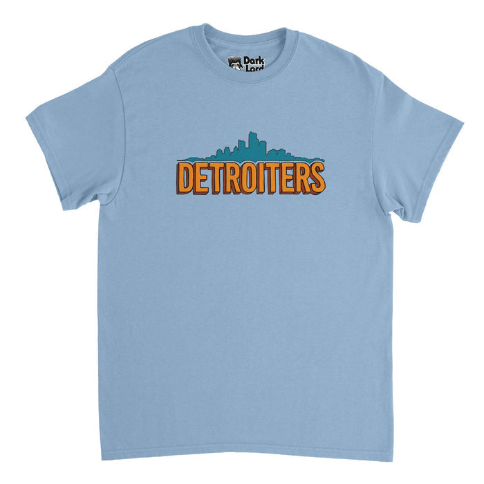 A retro, souvenir blue colored t-shirt that says "DETROITERS" in orange bubble letters with an image of the Detroit skyline filled in with aqua blue. References the hilarious American sitcom television show 'Detroiters' starring Tim Robinson and Sam Richardson.