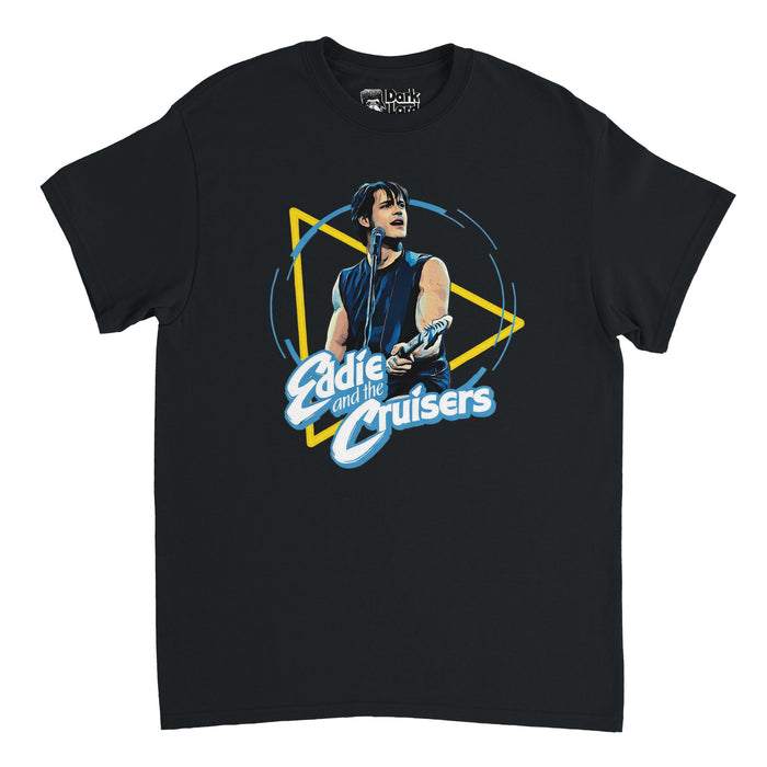 A retro short sleeved black t-shirt that says Eddie and the Cruisers underneath an image of Eddie Wilson in a black tank top singing at a microphone with a guitar. References the 1983 American musical drama film "Eddie and the Cruisers"directed by Martin Davidson, based on the P. F. Kluge novel, starring Tom Berenger and Michael Paré.