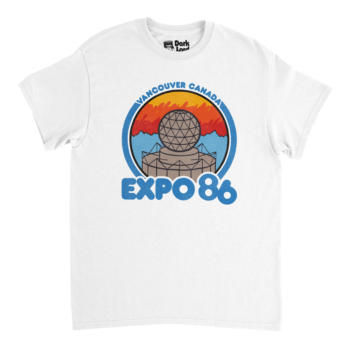 A retro white colored 80s style t-shirt that says "Vancouver Canada Expo 86" in reference to the 1986 World Fair - formerly known as the 1986 World Exposition on Transportation and Communication - which was held in Vancouver, British Columbia from May 2 - October 13. Shirt includes the image of a metal and steel globe ball / dome on a yellow, red, and blue background, in reference to the iconic landmark, the sphere, afterwards repurposed as Science world, now a beloved institution of science edu