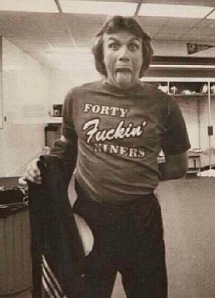 a man in a t - shirt is standing in an office