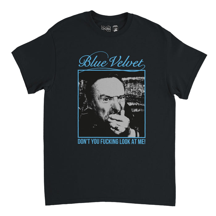 A vintage, 80s style, souvenir t-shirt in the color black that says Blue Velvet and the quote "Don't You Fucking Look at Me!" in blue letters with a blue frame around a square image of the character Frank Booth, played by Dennis Hopper, in David Lynch's psychological thriller film Blue Velvet.