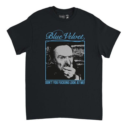 A vintage, 80s style, souvenir t-shirt in the color black that says Blue Velvet and the quote "Don't You Fucking Look at Me!" in blue letters with a blue frame around a square image of the character Frank Booth, played by Dennis Hopper, in David Lynch's psychological thriller film Blue Velvet.
