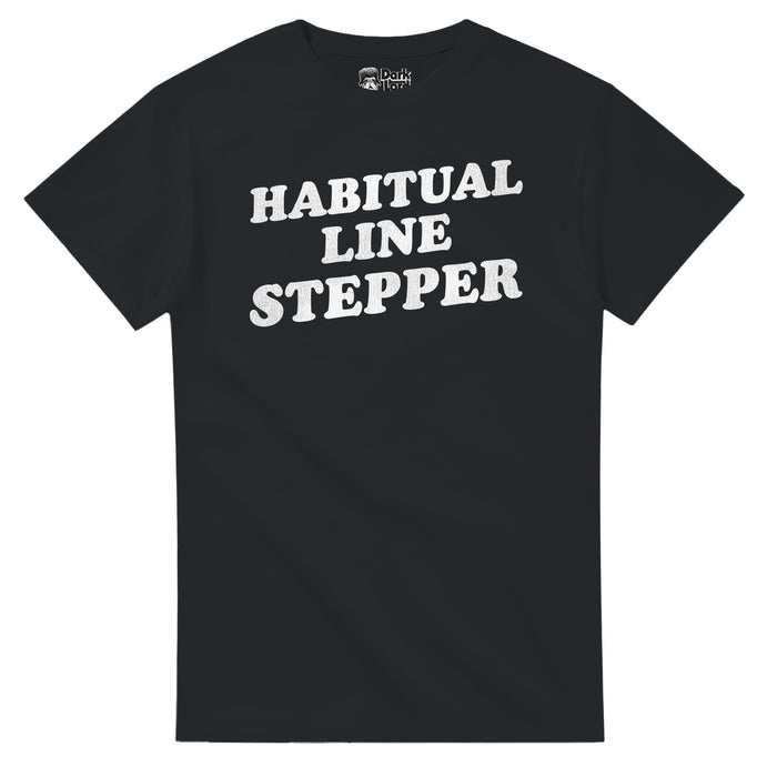 A retro, 70s style black colored short sleeved t-shirt that says "Habitual Line Stepper" in white bold text in reference to the comedy sketch Chappelle's Show created by comedians Dave Chappelle and Neal Brennan, specifically the Charlie Murphy sketch as he talks about Rick James.