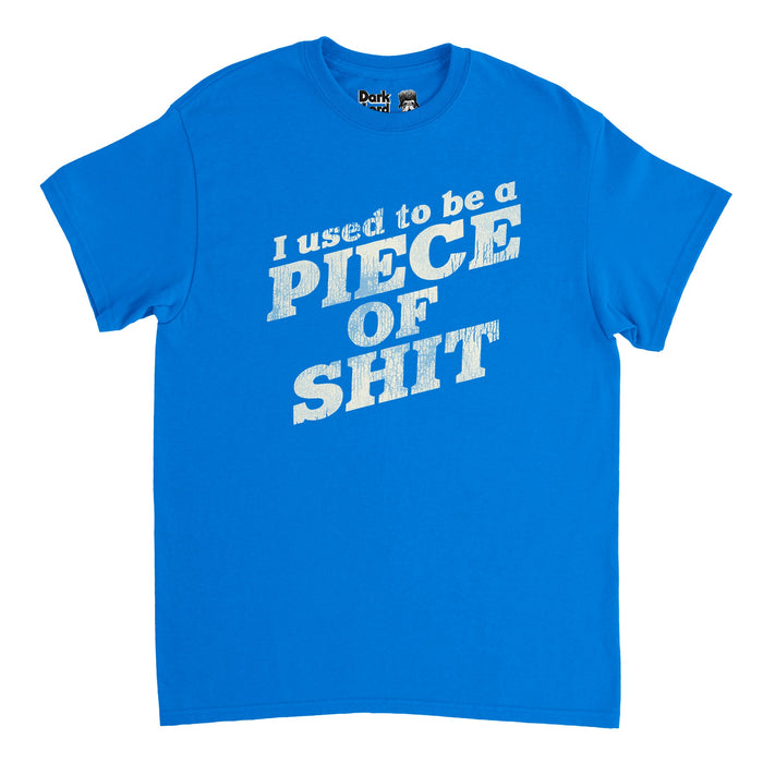 A souvenir 90s style t-shirt in the color blue which reads "I used to be a PIECE OF SHIT" in reference to the hilarious quote "I used to be a piece of shit. Slicked back hair, sloppy steaks at Pyloon’s. You would have not liked me back then." which comes from the sketch comedy TV show "I Think You Should Leave with Tim Robinson", created by Tim Robinson and Zach Kanin, specifically in the episode "Baby Cries".