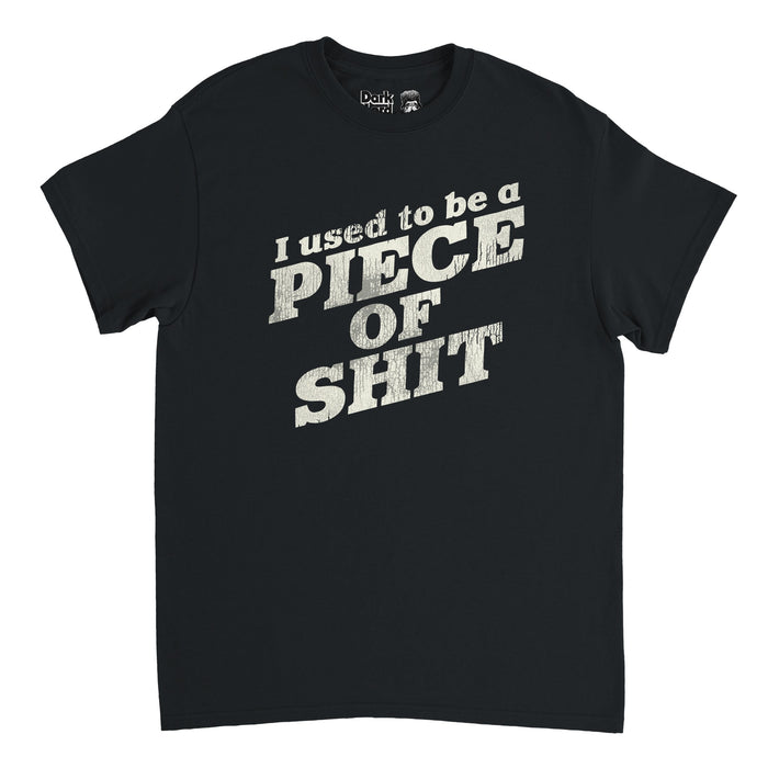 A black colored retro 80s style t-shirt that says "I used to be a PIECE OF SHIT" in reference to the iconic quote from the episode "Baby Cries" from the sketch comedy TV show "I Think You Should Leave with Tim Robinson" created by Robinson and Zach Kanin. The full quote goes "I used to be a piece of shit. Slicked back hair, sloppy steaks at Pyloon’s. You would have not liked me back then."