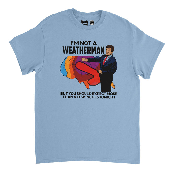 A retro, light blue colored 80s style short sleeved t-shirt that says the humorous quote "I'm not a weatherman but you should expect more than a few inches tonight" surrounding the image of a man in a suit pointing to a weather map of the united states with a red storm emanating from his suit and covering much of the United States in a very phallic shape.