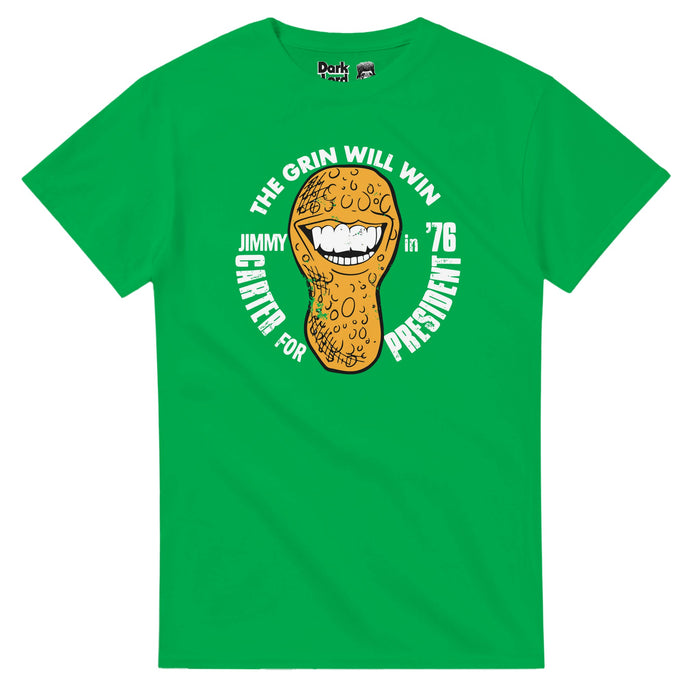 A retro, 70s style green colored t-shirt that says "The Grin Will Win, Jimmy Carter For President in '76" surrounding an image of a peanut with a huge wide toothed grin. References the 39th president of the United States, Jimmy Carter, who was originally a peanut farmer, which was often referenced during his campaign.