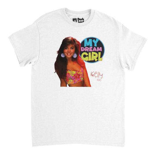 A souvenir, 90s style short sleeved t-shirt in white which says in yellow, pink, and blue bubble letters "My Dream Girl" beside the image of Kelly Kapowski from the famous 90s TV show "Saved by the Bell", played by the well known actress Tiffani Amber Thiessen. Shirt also says "Kelly XOXO" in pink letters with a small heart.