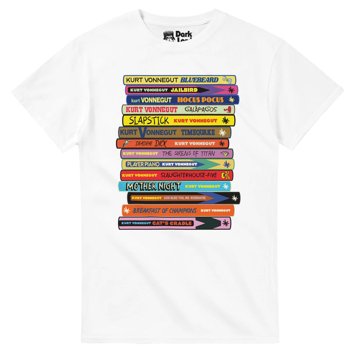 A white colored vintage, 80s sty t-shirt with the graphic of a large, colorful, designed stack of all 14 of Kurt Vonnegut's novels, including Bluebeard, Jailbird, Hocus Pocus, Slapstick, Timequake, Deadeye Dick, The Sirens of Titan, Player Piano, Slaughterhouse-Five, Mother Night, God Bless You, Mr. Rosewater, Breakfast of Champions, and Cat's Cradle, in reference to the well known, revolutionary American author Kurt Vonnegut, Jr., famous for his satirical writing, dark humor, and science fictio