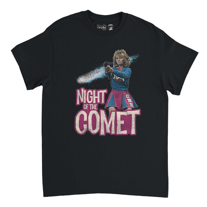 A retro, 70s style black colored short sleeved t-shirt that says "Night of the Comet" in white text surrounded by pink, referencing the iconic horror sci fi 1984 film of the same name, with an image of character Samantha "Sam" Belmont, played by famous actress Kelli Maloney, stands in a cheerleading pink and blue outfit with the letters CHS holding a gun.