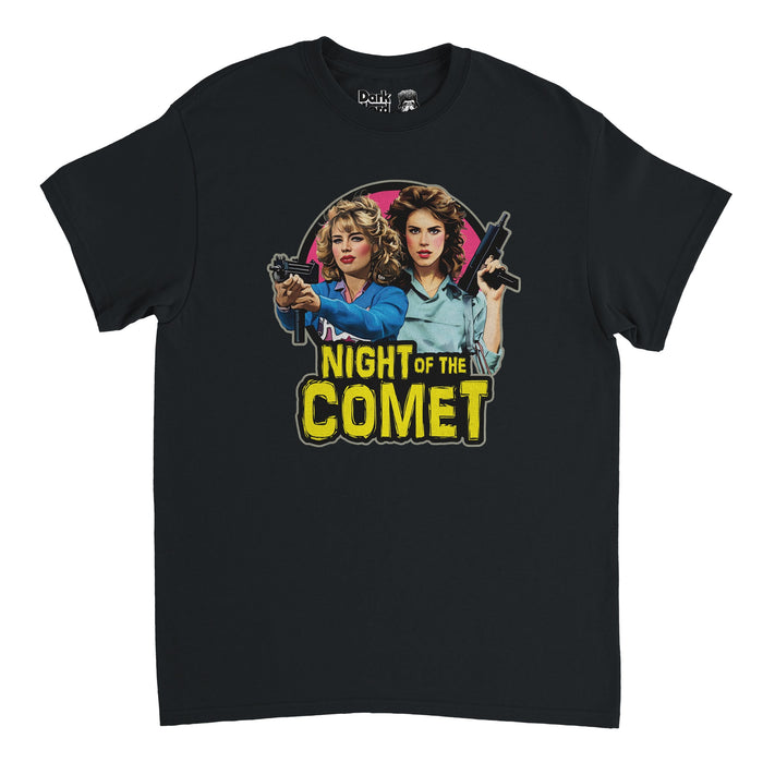 A black colored souvenir 90s retro shirt with the image of two women, actors Kelli Maroney as Sam and Catherine Mary Stewart as Reggie, wield guns with intense stares, willing to protect their loved ones, on a circular pink backgound. Says "Night of the Comet" in bright yellow text with a font resembling Halloween theme, in references to the horror movie of the same name about zombies, a comet, and saving the world.