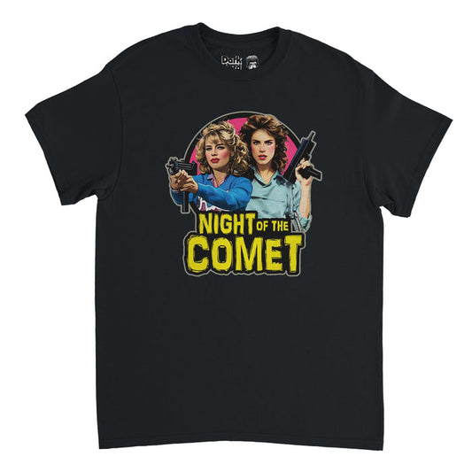 A black colored souvenir 90s retro shirt with the image of two women, actors Kelli Maroney as Sam and Catherine Mary Stewart as Reggie, wield guns with intense stares, willing to protect their loved ones, on a circular pink backgound. Says "Night of the Comet" in bright yellow text with a font resembling Halloween theme, in references to the horror movie of the same name about zombies, a comet, and saving the world.