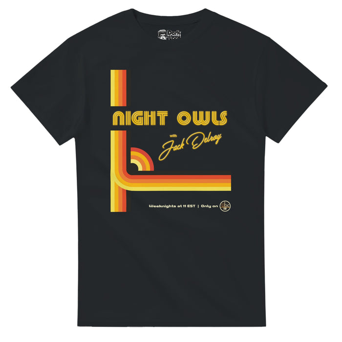 A black colored 70s style souvenir t-shirt that says "Night Owls with Jack Delroy" and includes multiple five colored stripes - from yellow to orange to black - forming graphic shapes across the shirt, like a small rainbow, and says 'Weeknights at 11 EST, Only on UBC TV." In reference to Colin and Cameron Cairnes' "Late Night with the Devil" in which David Dastmalchian plays late night host Jack Delroy, constantly trying to beat Johnny Carson's "Tonight Show", and takes place on Halloween of 19