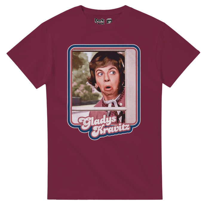A retro, souvenir magenta colored short sleeve t-shirt with a rectangular image of character Gladys Kravitz peeking through the window wearing a pink sweater, the image outlined by blue and pink lines, her name written out at the bottom in pink: "Gladys Kravitz". References the iconic image of Alice Pearce played the nosy neighbor Gladys Kravitz from the fantasy tv series Bewitched from the 60s and 70s.