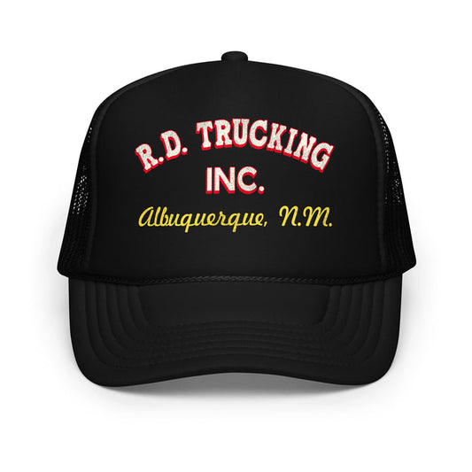 A retro, 70s style black colored foam trucker hat that says "R.D. Trucking Inc." in red and white letters and "Albuquerque, N.M." in yellow, cursive letters. In reference the 1978 road action film "Convoy", directed by Sam Peckinpah", starring Kris Kristofferson as character 'Rubber Duck' and Ali MacGraw as Melissa.