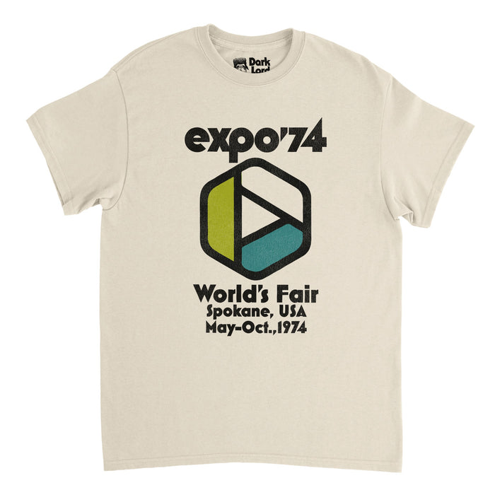 A retro, souvenir soft cream colored t-shirt that says "expo '74" and "World's Fair", "Spokane, USA", "May-Oct., 1974". Includes the logo of the Spokane World's Fair, a stylized Möbius strip in colors white, blue, and green, representing the connectedness of life and the environment, representative of its theme of environmental protection, famous for the debut of the IMAX movie theater.