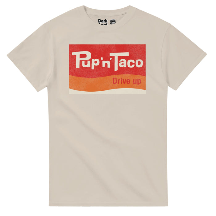 A souvenir vintage off white colored t-shirt that has the iconic Pup 'n' Taco Drive Up logo with wavy blocks of red, orange, & white, which references the Californian fast food chain popular in the 50s, 60s, 70s, and 80s, created by Russell Wendell in Pasadena, most of which was sold to Taco Bell in the 80s with a couple remaining locations in Albuquerque, New Mexico until the 2010s. Referenced in the comedy "Fletch", the film "The Runaways", "America's Court with Judge Ross", and the "Tonight S