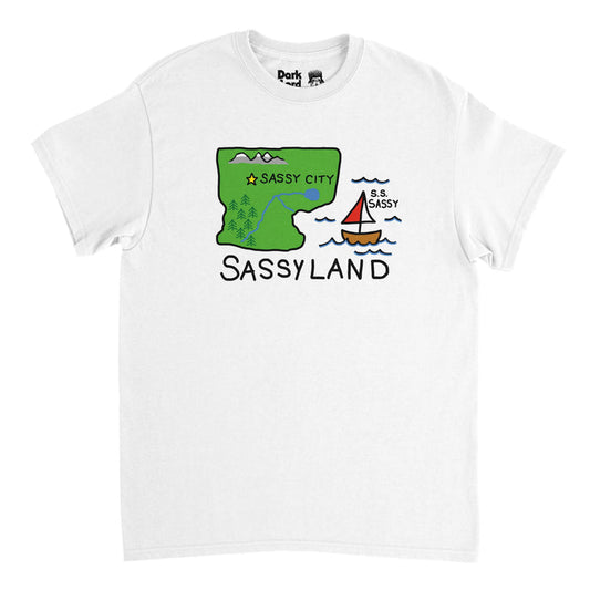 A vintage, 70s style t-shirt in the color white with the graphic of a map including a green piece of land with trees, rivers, a lake, mountains, and "Sassy City" next to a yellow star and an ocean with an "S.S. Sassy" sailboat, the location called "Sassyland." In reference to the iconic SNL skit called 'Sassy's Sassiest Boys' in which Phil Hartman, portrayed by Russell Clark, interviews famous actor Christian Slater, Joey Lawrence (portrayed by Mike Myers) and Andrew McCarthy (portrayed by Jay M