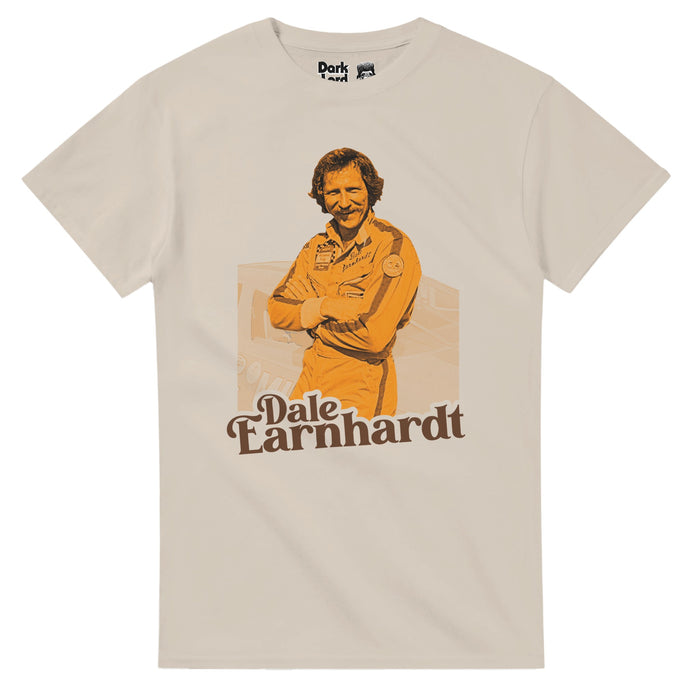A retro, sand colored short sleeved vintage t-shirt that says "Dale Earnhardt" underneath a yellow toned image of the iconic professional stock car driver and racing team owner wearing his uniform, standing against his car, famously a No. 3 Chevrolet car, with nicknames like "The Intimidator", "The Man in Black", and "Ironhead", known as one of the greatest NASCAR drivers of all time.