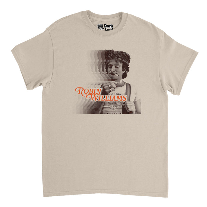 A retro, sand colored vintage off white 70s style t-shirt that says ROBIN WILLIAMS in bright range letters above a famous image of the actor and comedian smoking a cigarette, holding his suspenders over a t-shirt, rings on his fingers. The image is reflected multiples times and overlaps itself on the shirt.