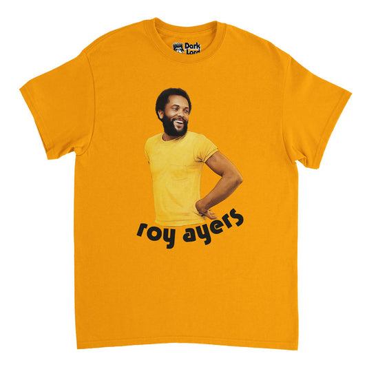 A vintage, souvenir orange colored t-shirt that says "Roy Ayers" underneath an image of the incredible musician, singer, and vibraphonist who pioneered jazz-funk and had hits like "You Send Me", "I Am Your Mind", and "Liquid Love". References the image on the front of his famous album "Everybody Loves the Sunshine" by his band, Roy Ayers Ubiquity.