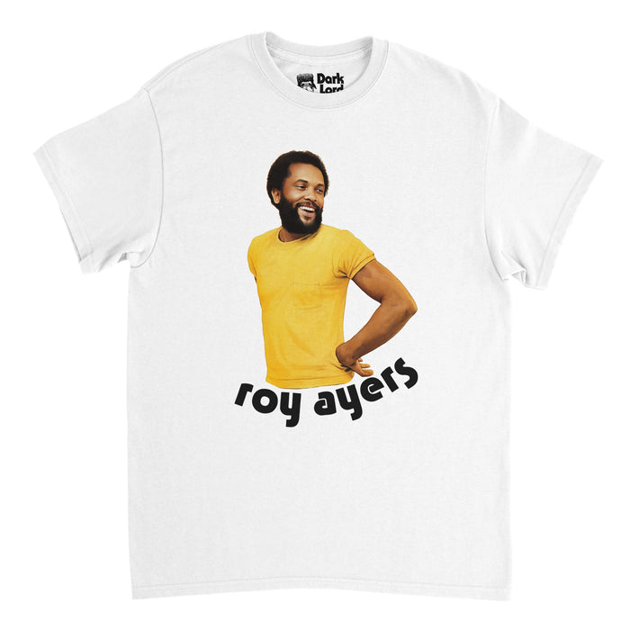A retro, 70s style white t-shirt that says "roy ayers" in lowercase black letters underneath the image of the composer and musician himself, wearing a yellow shirt, smiling to the side, an iconic musician, vibraphonist, and post jazz artist  who eventually pioneered jazz funk. The shirt references his famous album "Everybody Loves the Sunshine", with his image being the same one used on the album cover.