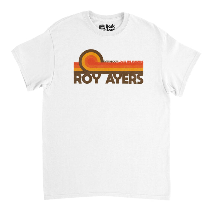 A retro, 70s style souvenir white colored t-shirt that says ROY AYERS in brown text underneath swirling lines of brown, yellow, orange, and red, on top of which is the title of the singer and vibraphonist's most famous album, an R&B soul jazz collection titled "Everybody Loves The Sunshine" from the year 1976.