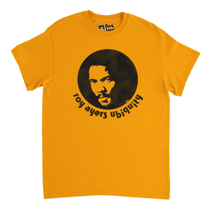 A retro, 80s style light orange t-shirt that says "roy ayers ubiquity" under a black and white image of the iconic singer, musician, and vibraphonist himself. In reference to Roy Ayers' band, with whom he released his most famous album and song "Everybody Loves the Sunshine", and the same shirt he wore to perform at the Kool Festival in Cincinnati in 1976 right after the release of the iconic album.