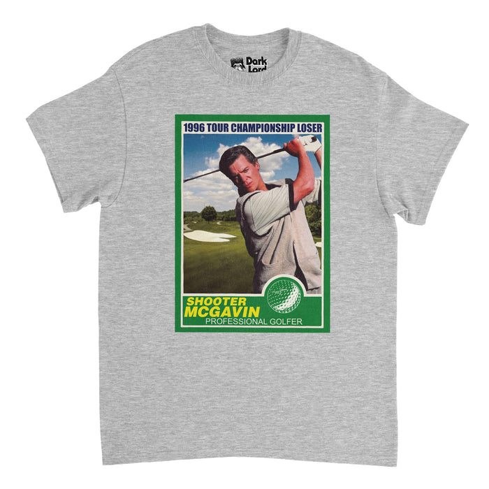 A heather gray 70s style souvenir t-shirt that says "1996 Tour Championship Loser" and "Shooter McGavin, Professional Golfer" with an image of the character Shooter McGavin on a driving range, swinging his golf club, wearing a gray shirt and a graphic of a golf ball, outline by a forest green rectangular box. References the villainous professional golf player and fan favorite antagonist Shooter McGavin, played by Christopher McDonald, in the sports comedy movie Happy Gilmore.
