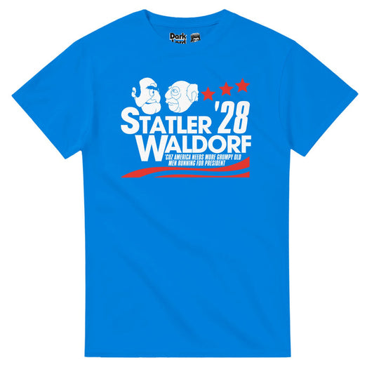 A retro, bright blue 70s style short sleeved t-shirt that says "Statler Waldorf '28, 'Cuz America Needs More Grumpy Old Men Running For President" with an image of the two iconic muppets, always bickering, staring at each other, and with red colored campaigning graphics like stars & stripes on the shirt. References the iconic series "The Muppet Show" and the always negative Statler and Waldorf who ran for president, performed by multiple acotrs including Richard Hunt, Jerry Nelson, Jim Henson, &