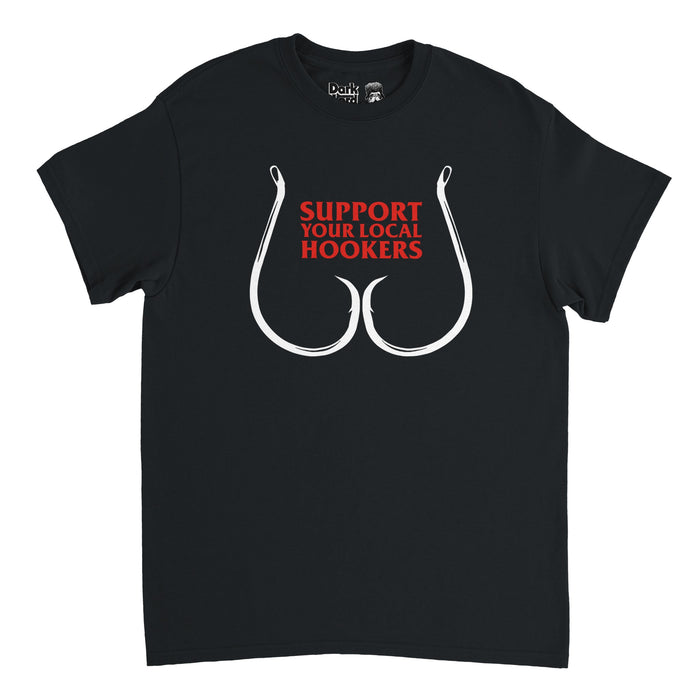 A retro, souvenir black colored t-shirt that says in bright red text the pun Support Your Local Hookers" above an image of two fishing hooks in the shape of breasts.