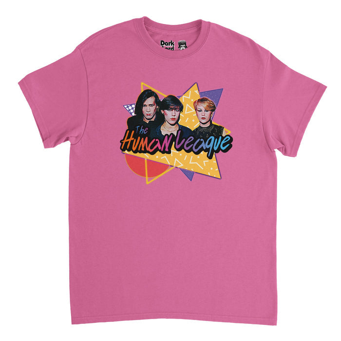 A retro, 70s style pink t-shirt with triangular and circular yellow and purple shapes overlapping each other, filled with various patterns, with band members Philip Oakey, Joanne Catherall, and Susan Ann Sulley shown with dark makeup and clothing under "The Human League", written in purple, orange, blue, & pink colors in reference to the English synth band from Sheffield which became famous from the album "Dare" and had hits like "Don't You Want Me", "Human", "Open Your Heart", & "The Sound of t
