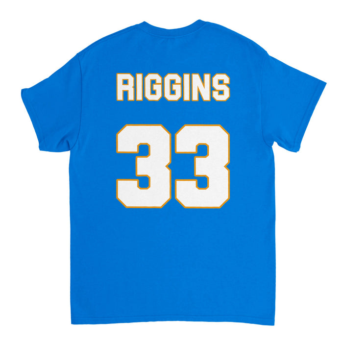 The back of a bright blue short sleeved vintage 80s style t-shirt that says "RIGGINS" in all caps and has the number 33 in white block text, outlined in yellow. References the jersey worn by character Tim Riggins, played by actor Taylor Kitsch, on the Dillon Panthers football team in the American sports drama tv series "Friday Night Lights".