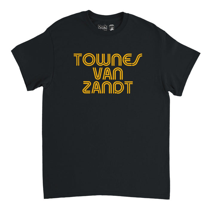 A retro, short sleeved 80s style t-shirt that says in yellow lined text "TOWNES VAN ZANDT" in reference to the famous American singer-songwriter with hit songs like "Pancho and Lefty", "Snake Mountain Blues", To Live's to Fly", and "If I Needed You", famous for his melancholic, poetic lyrics.