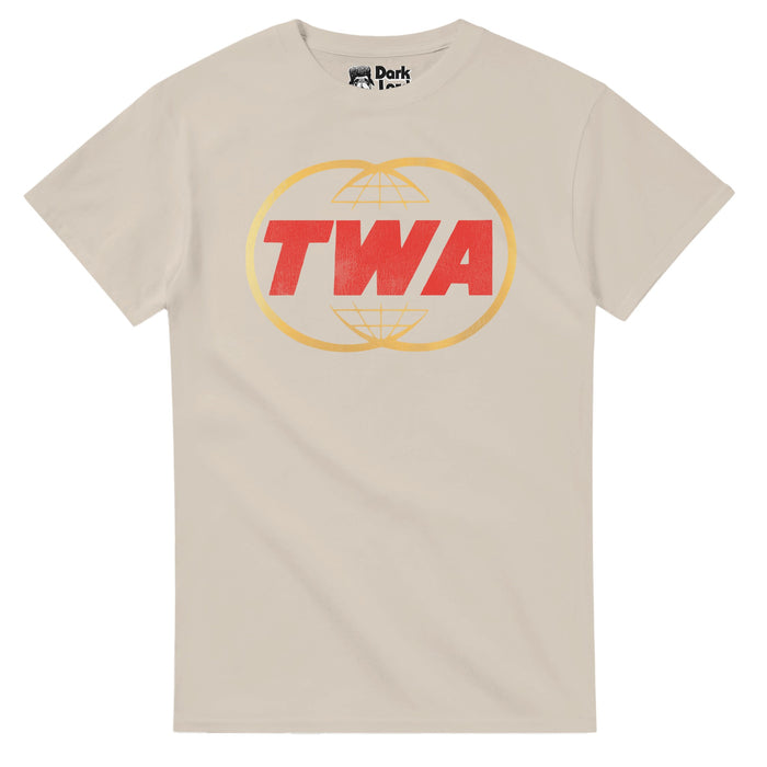 A retro, sand colored light brown souvenir t-shirt with the letters "TWA" in bold red surrounded by two circles, globes, intersecting in the middle. References the trunk carrier airline that first started in the 1930s and operated through the 1900s until 2001, when American Airlines bought it, originally known as one of the "Big Four" US domestic airlines, later international, and in the 1960s one of the world's largest airlines.