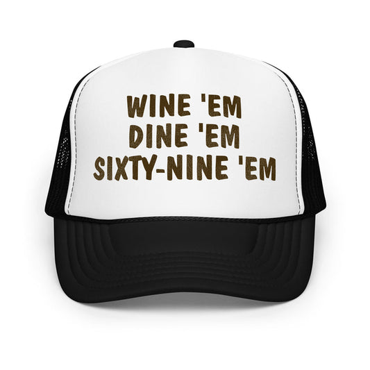 A retro, souvenir white and black foam trucker hat and costume with the words "Wine 'Em Dine 'Em Sixty-Nine 'Em" on the front in bold black letters. References the iconic hat made famous by the character Sea Bass, played by legendary NHL hockey player and actor Cam Neely, which he wore in the movie "Dumb and Dumber".